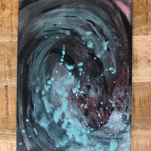An abstract emotional drawing canvas art print painting of a swirling cosmic vortex with teal, black, and red tones, displayed on a light wood background.