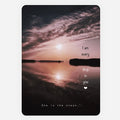 A rectangular art print or greeting  card featuring a sunset over calm water, with overlaid quote reading 'I am every drop in you' and 'She is the ocean'. The print is shown centered on a light gray background.