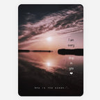 A rectangular art print or greeting  card featuring a sunset over calm water, with overlaid quote reading 'I am every drop in you' and 'She is the ocean'. The print is shown centered on a light gray background.