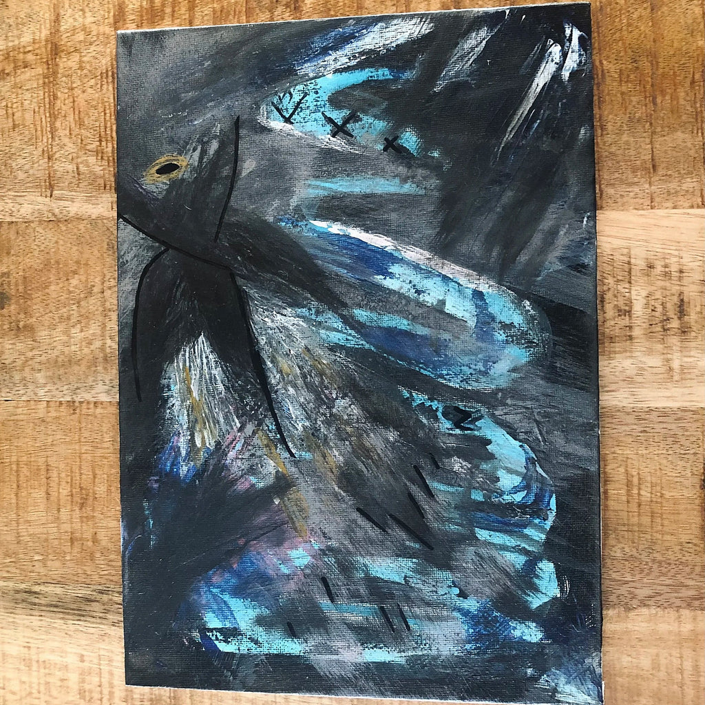 An abstract emotional canvas art print mixed-media painting featuring expressive brushstrokes in black, gray, and vibrant blue, with a small yellow accent near the upper left, displayed on a wooden surface.
