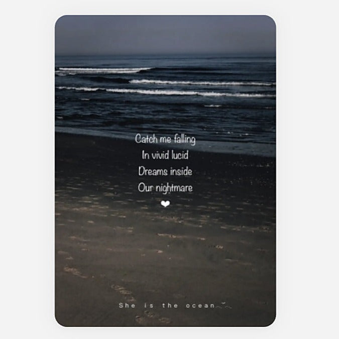 A rectangular art print greeting Card with rounded corners featuring a moody beach scene at dusk or dawn, with ocean waves, dark sand, and white overlaid quote reading 'Catch me falling / In vivid lucid / Dreams inside / Our nightmare' plus 'She is the ocean' at the bottom.