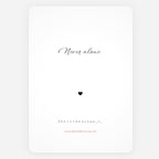 A minimalist white art print greeting card with rounded corners, featuring the quote 'Never alone' in black cursive, a small black heart, and additional text 'She is the ocean' with a small red website URL at the bottom.